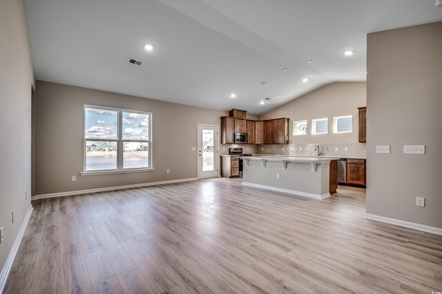 179 Glengrove Ln, Murrells Inlet, SC 29576 - kitchen with light countertops, light wood finished floors, stainless steel appliances, open floor plan, and a kitchen breakfast bar