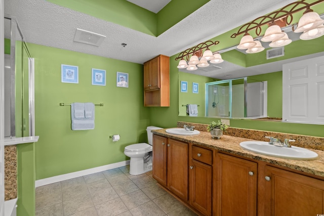 full bathroom featuring a shower stall, a textured ceiling, visible vents, and a sink