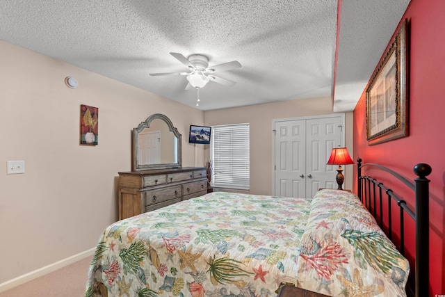 carpeted bedroom featuring a textured ceiling, a closet, a ceiling fan, and baseboards