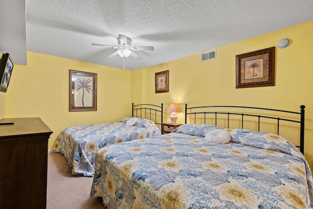 carpeted bedroom with ceiling fan, visible vents, and a textured ceiling