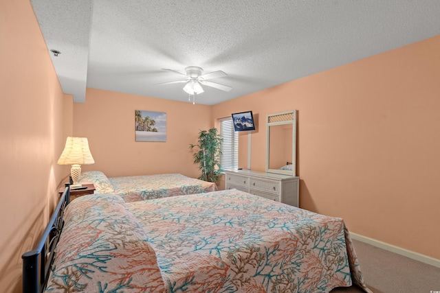 carpeted bedroom with a ceiling fan, baseboards, and a textured ceiling