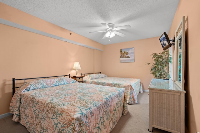 carpeted bedroom with a ceiling fan, a textured ceiling, and baseboards