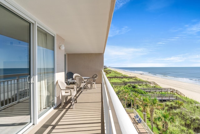 balcony featuring a water view and a view of the beach