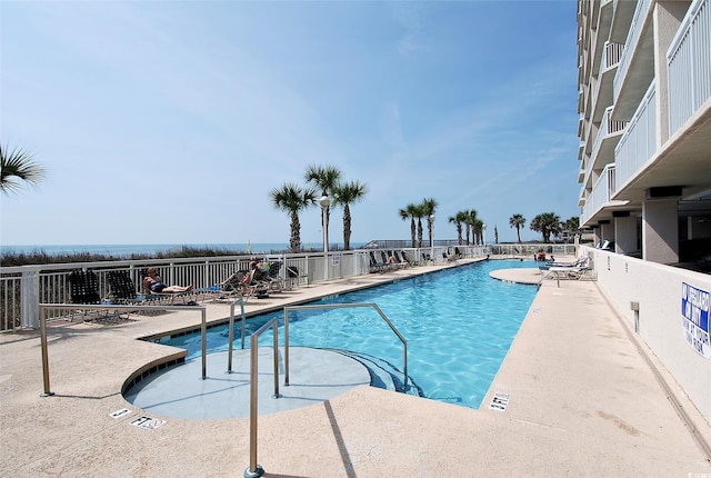 pool with a patio area and fence