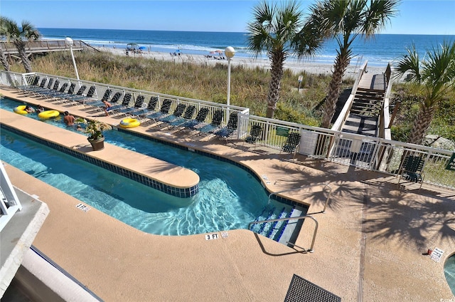 community pool featuring a water view and a beach view