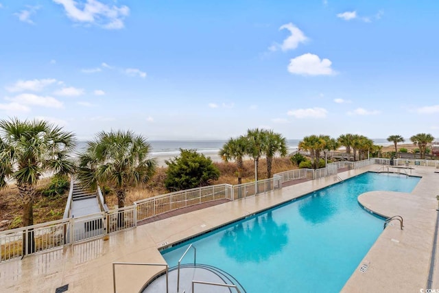 community pool with a patio and fence