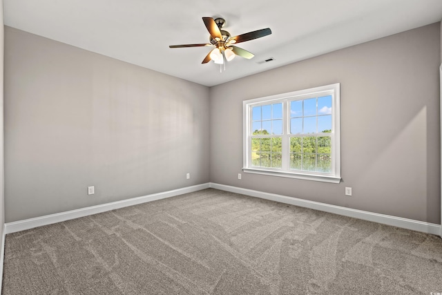 carpeted empty room featuring visible vents, baseboards, and ceiling fan