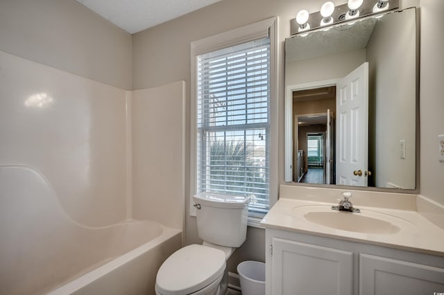 full bath with  shower combination, vanity, toilet, and a textured ceiling