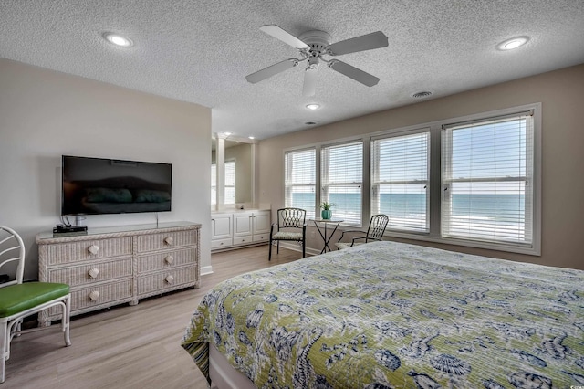 bedroom featuring light wood-type flooring, visible vents, a textured ceiling, and recessed lighting