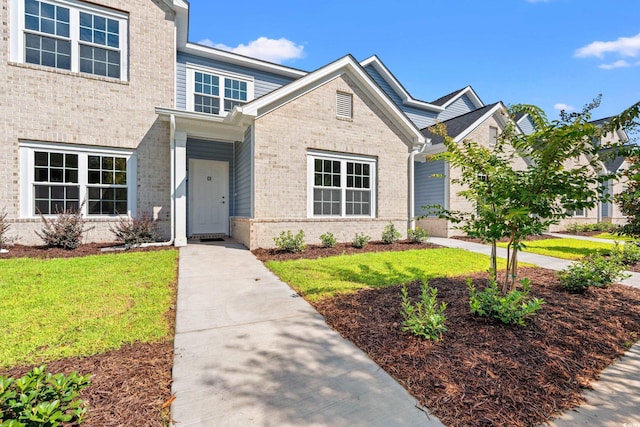 view of front of house featuring a front yard and brick siding