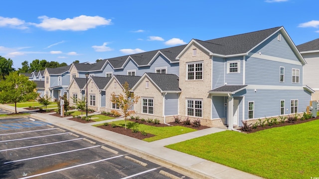 view of property featuring uncovered parking, a front yard, and a residential view