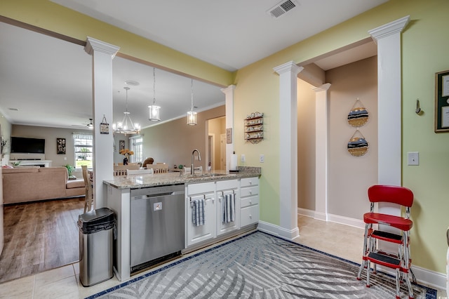 kitchen with light stone counters, visible vents, ornate columns, dishwasher, and a sink