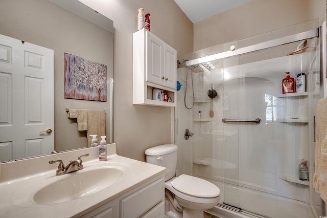 bathroom featuring toilet, a stall shower, and vanity