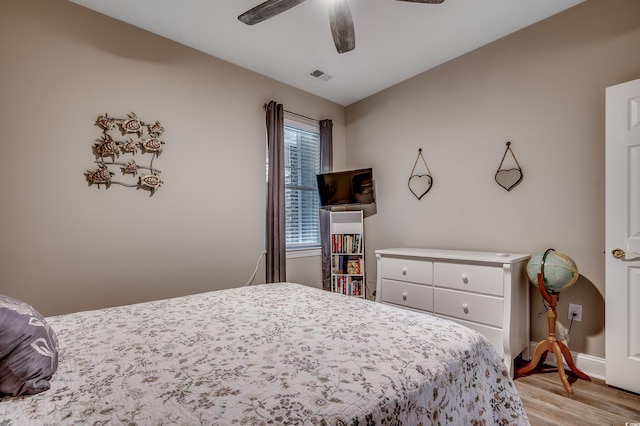 bedroom featuring visible vents, light wood-style flooring, a ceiling fan, and baseboards