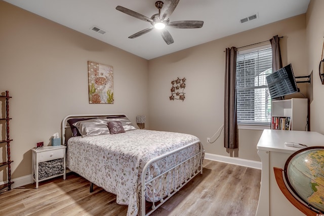 bedroom with visible vents, light wood-type flooring, and baseboards