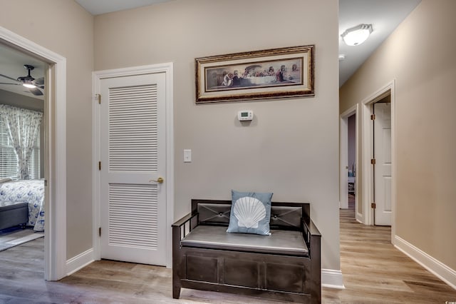 doorway with baseboards, a ceiling fan, and wood finished floors