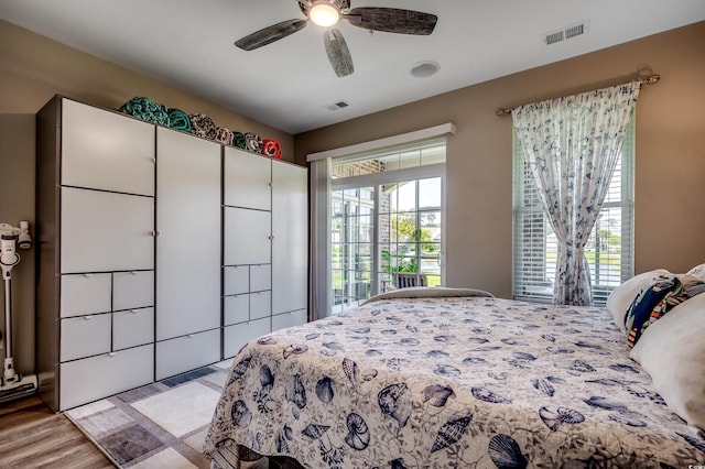 bedroom with light wood-style flooring, a ceiling fan, and visible vents