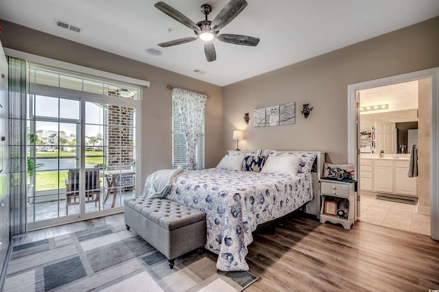 bedroom featuring light wood-type flooring, visible vents, access to outside, and ensuite bath