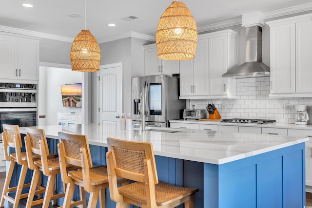 kitchen featuring crown molding, stainless steel appliances, tasteful backsplash, visible vents, and wall chimney range hood