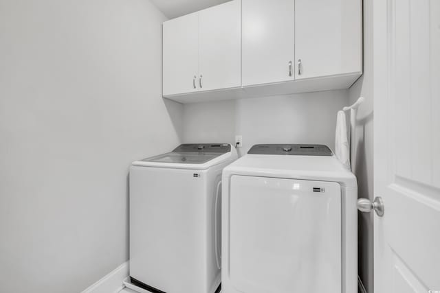 clothes washing area with cabinet space and washing machine and clothes dryer