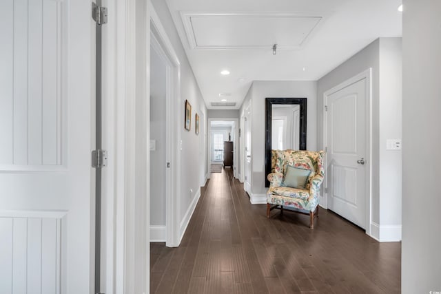 corridor featuring attic access, baseboards, dark wood-style flooring, and recessed lighting