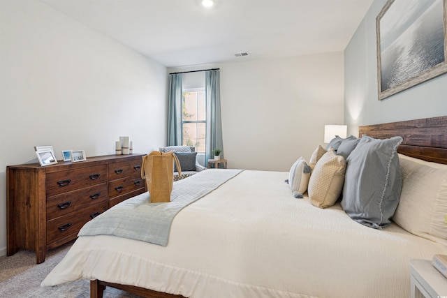 bedroom featuring visible vents and light carpet