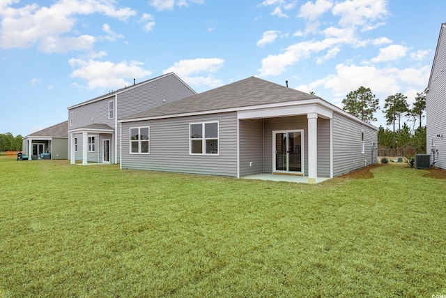 rear view of property featuring a patio, a shingled roof, a lawn, and central air condition unit