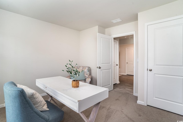 home office with visible vents, baseboards, and light colored carpet