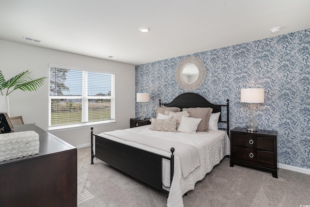 carpeted bedroom with baseboards, visible vents, and wallpapered walls