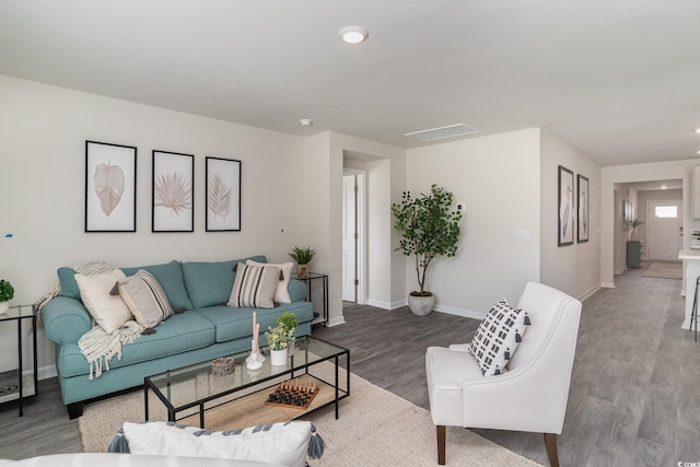 living room featuring wood finished floors, visible vents, and baseboards