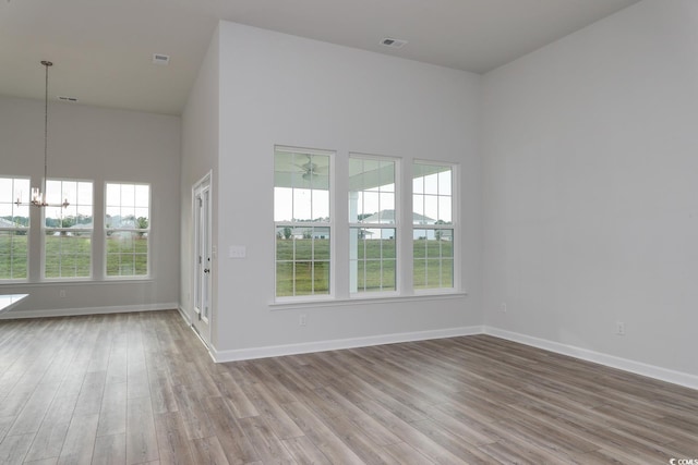 4036 Bucolic Loop, Myrtle Beach, SC 29588 - unfurnished room with healthy amount of natural light, a chandelier, wood finished floors, a high ceiling, and ceiling fan