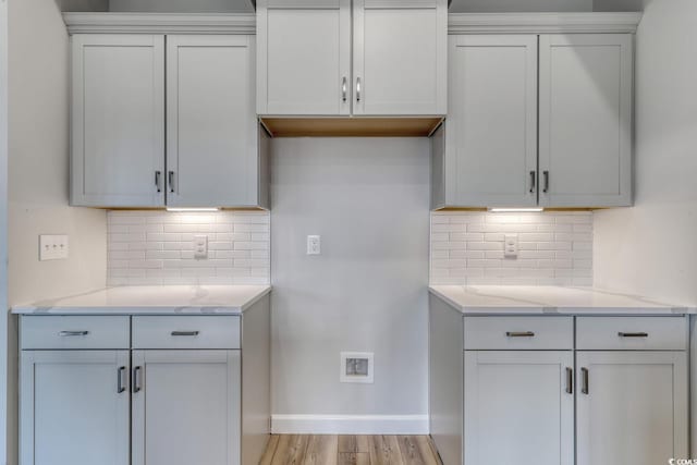 4036 Bucolic Loop, Myrtle Beach, SC 29588 - kitchen featuring decorative backsplash, light stone counters, and light wood-style floors