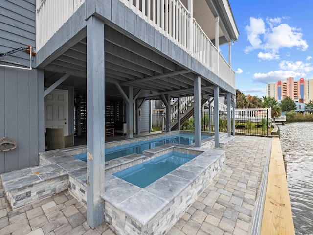 outdoor pool with stairs, an in ground hot tub, and a patio