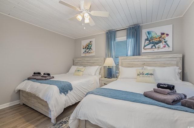 bedroom with a ceiling fan, wood ceiling, baseboards, and wood finished floors