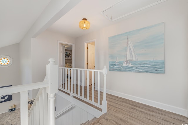 corridor featuring attic access, baseboards, an upstairs landing, and wood finished floors