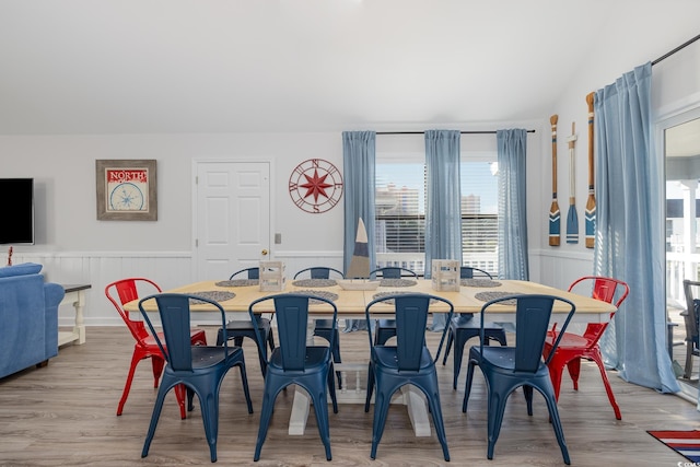 dining space featuring a wainscoted wall and wood finished floors