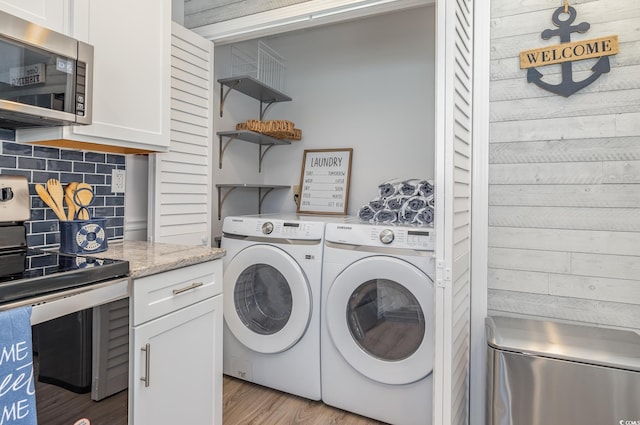 laundry room with laundry area, independent washer and dryer, and wood finished floors