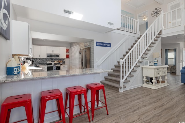 kitchen featuring light wood-style floors, visible vents, stainless steel appliances, and a sink