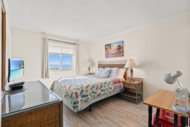 bedroom with a textured ceiling and wood finished floors