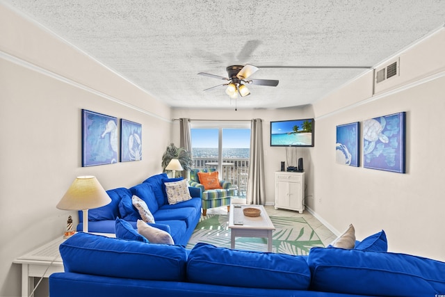 tiled living room with a ceiling fan, visible vents, a textured ceiling, and baseboards