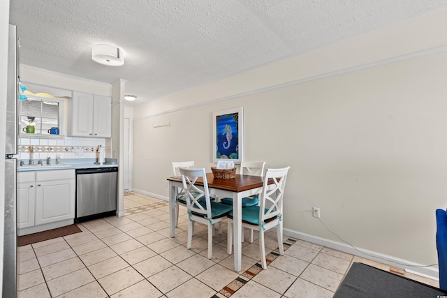 dining room featuring light tile patterned flooring, a textured ceiling, and baseboards