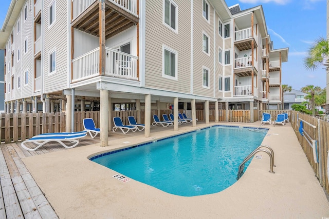 pool with fence and a patio