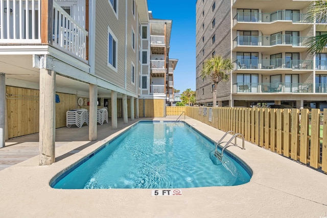 community pool featuring a patio area and fence