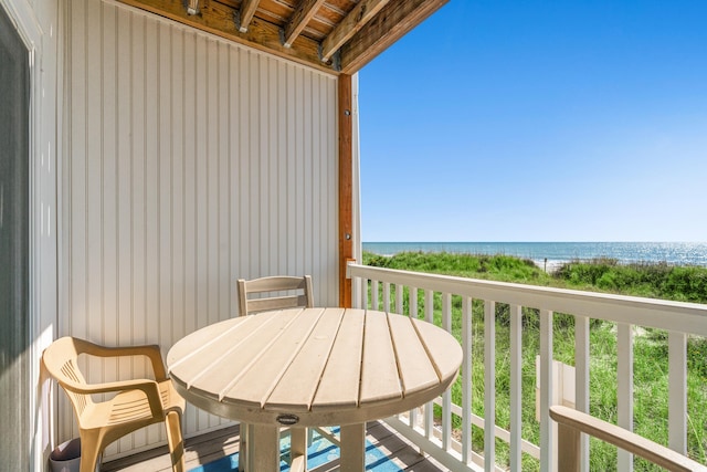 balcony featuring outdoor dining area and a water view