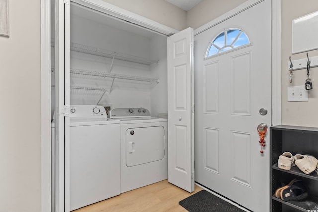 laundry room featuring laundry area, light wood-style flooring, and washing machine and clothes dryer