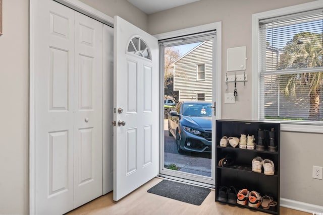 entryway with light wood-style flooring, baseboards, and a wealth of natural light