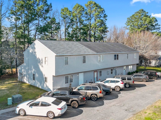 view of front facade with a front yard and roof with shingles