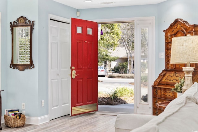 entryway featuring visible vents, baseboards, and wood finished floors