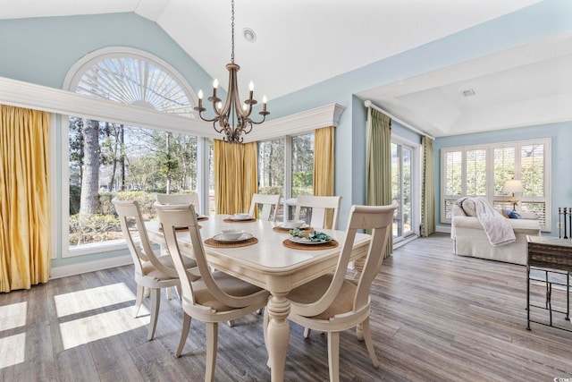 dining room featuring lofted ceiling, a chandelier, and wood finished floors