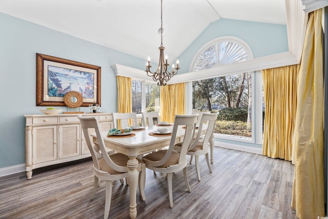 dining area featuring a healthy amount of sunlight, light wood-style flooring, a chandelier, and baseboards